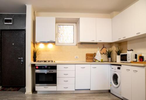 a kitchen with white cabinets and a dishwasher at Aquarium Apartment Grivita in Bucharest