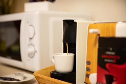 a coffee maker is sitting next to a coffee cup at Aquarium Apartment Grivita in Bucharest
