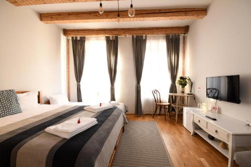 a hotel room with two beds and a desk at Wood House Republicii in Braşov