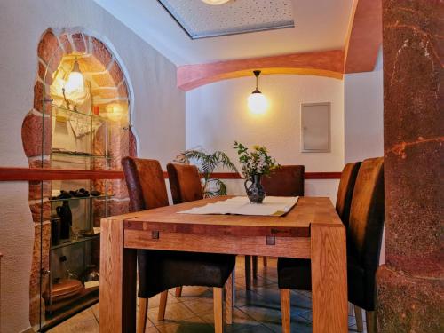 a dining room with a wooden table and chairs at Ferienwohnung Hegemühle in Geithain