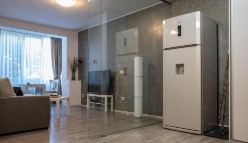 a living room with a white refrigerator in a room at Aquarium Apartment Grivita in Bucharest