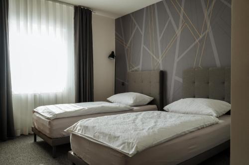 2 Einzelbetten in einem Zimmer mit Fenster in der Unterkunft Guest House Tri Zvezde in Kočevje