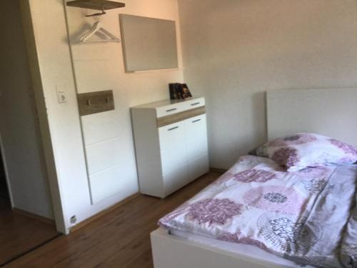 a small bedroom with a bed and a mirror at Bokelrehm 3 in Bokelrehm