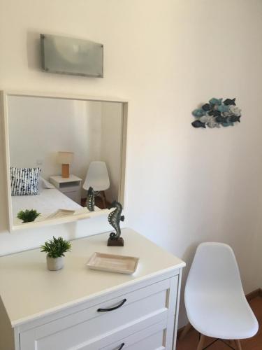 escritorio blanco con silla blanca y espejo en Casa Maré, en Sagres