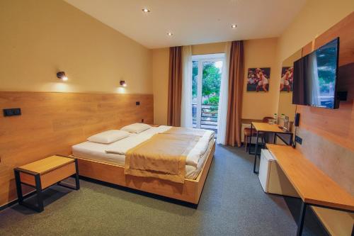 sypialnia z dużym łóżkiem i telewizorem w obiekcie Sport Hotel w Czerkasach