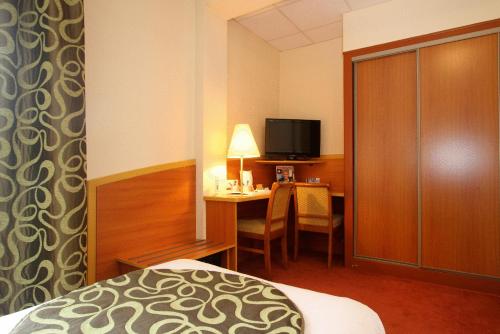 a hotel room with a bed and a television at Kyriad Hotel Lamballe in Lamballe
