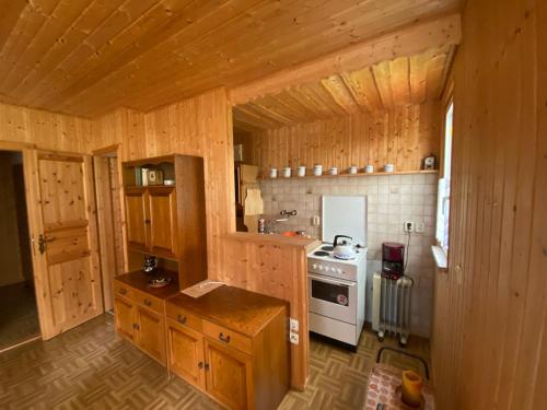 cocina con armarios de madera y estufa blanca en Waldfrieden Bungalow, en Garnsdorf