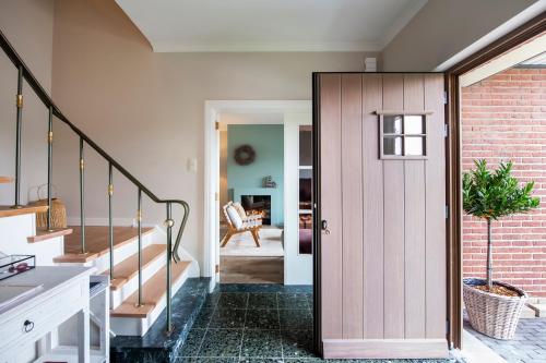 a pivot door in a home with a staircase at Huize Idalie in Bilzen