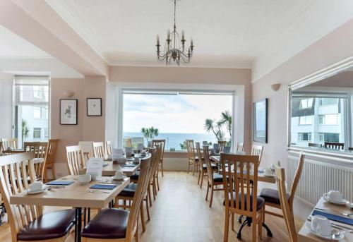 a dining room with a table and chairs and a large window at Anacapri in Falmouth