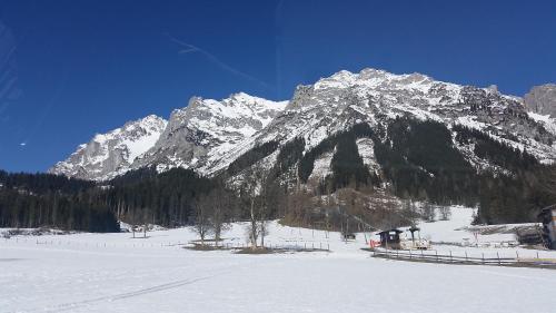 a snow covered mountain in front of a snow covered mountain at Haus Klager in Ramsau am Dachstein