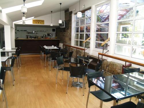 - une salle à manger avec des tables, des chaises et des fenêtres dans l'établissement Hotel Santos, à Guarda