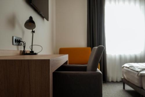 una habitación con un escritorio, una silla y una cama en Guest House Tri Zvezde, en Kočevje
