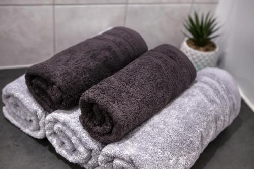 three towels sitting on a counter in a bathroom at J-Mo Home - Magny - Moderne et chaleureux in Magny-le-Hongre