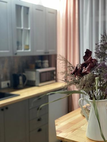 a vase with flowers on a table in a kitchen at Apartamenty Liwa in Kwidzyn