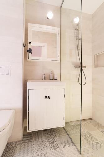 a white bathroom with a sink and a shower at Pr`Mružo apartmaji in Bohinj