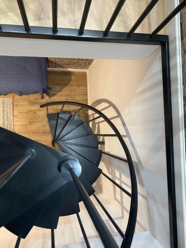 a spiral staircase in a house with a black chair at Apartamenty Liwa in Kwidzyn