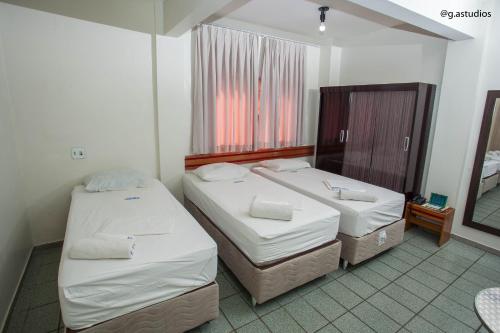 2 aparte bedden in een kamer met een spiegel bij HOTEL ZURIQUE in Patos
