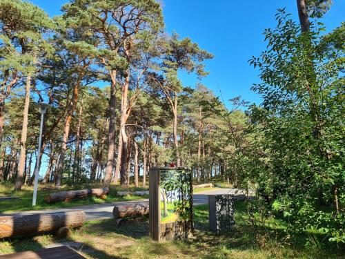 a sign in a park with trees in the background at Strandhaus Rügen - Meerblick, Sauna, Kamin & Whirlpool in Baabe