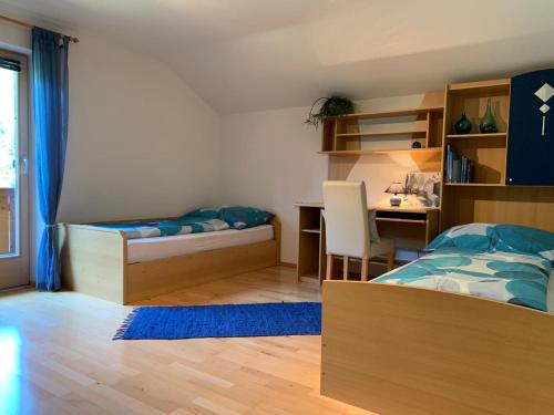 a bedroom with a bed and a desk and a bed and a table at Haus Huberta in Achenkirch