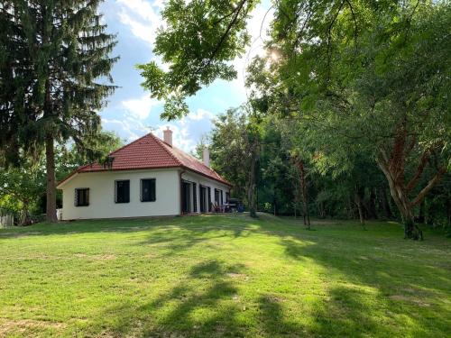 una casa en un patio con un gran campo de césped en Luxury Cottage by Little Danube - Pista & Magduska en Čierna Voda