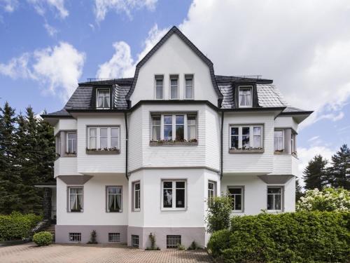 una casa blanca con techo negro en Villa Siegfried, en Bad Steben