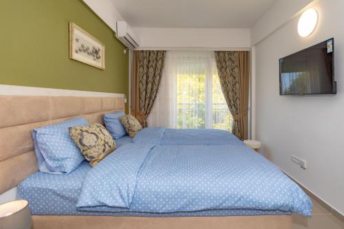 a bedroom with a blue bed and a television at Sea&Center Lux in Bar