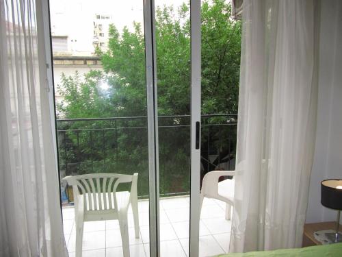 une porte coulissante en verre ouverte avec une chaise sur un balcon dans l'établissement French I Recoleta, à Buenos Aires