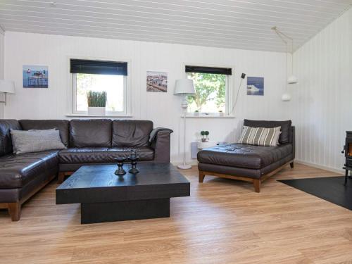 ヒュールスミンネにある6 person holiday home in Juelsmindeのリビングルーム(革張りのソファ、コーヒーテーブル付)