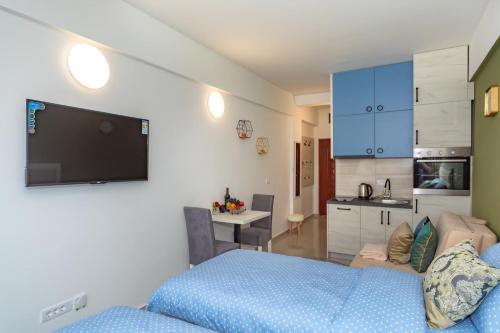 a bedroom with a blue bed and a kitchen at Sea&Center Lux in Bar