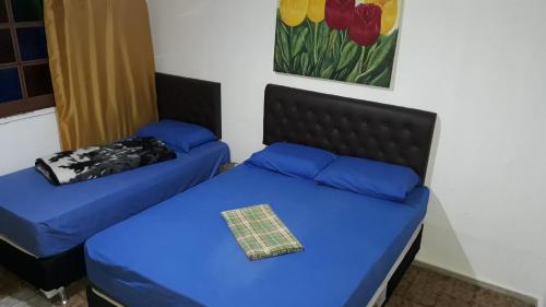 a bedroom with two beds with blue sheets at Hostel Gerais in Belo Horizonte