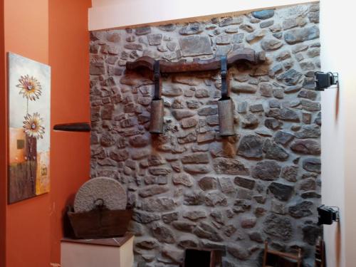 Una pared de piedra en una habitación con tuberías. en Casa rural La Media Legua en Villoslada de Cameros