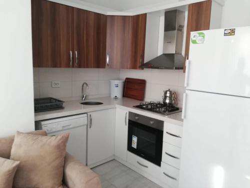 eine Küche mit einem weißen Kühlschrank und einem Herd in der Unterkunft Dalaman Airport Daltur Aparts in Dalaman