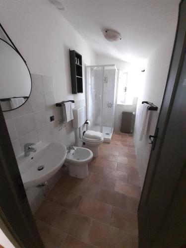 a bathroom with a toilet and a sink and a shower at Cascina Merlo Country House in Pareto