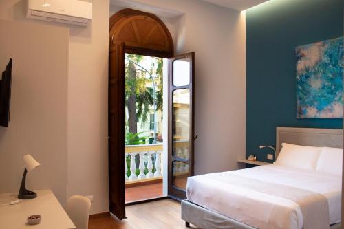 a bedroom with a bed and a door to a balcony at Relais Villa Montedonzelli in Naples