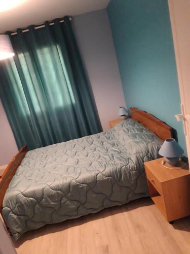 - une chambre avec un lit et un rideau vert dans l'établissement Jura belle vue, à La Loye