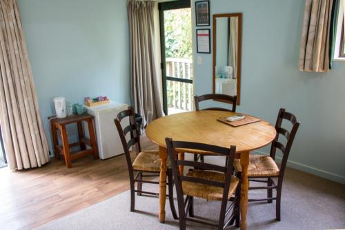 a wooden table and chairs in a room with a window at River Valley Lodge in Taihape