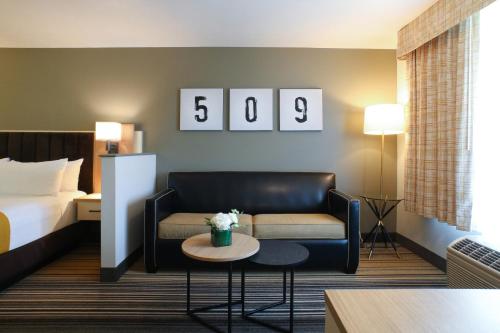 a hotel room with a couch and a bed at Oxford Suites Spokane Valley in Spokane Valley