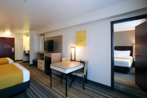 a hotel room with two beds and a desk and a mirror at Oxford Suites Spokane Valley in Spokane Valley