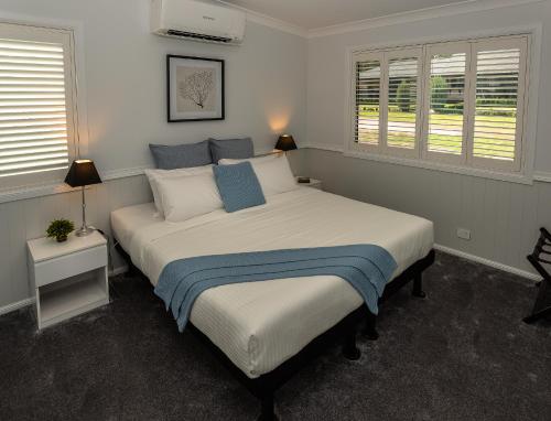 1 dormitorio con 1 cama grande con almohadas azules y blancas en Bella Vista Stanthorpe en Stanthorpe