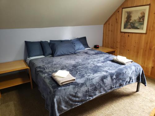 a bedroom with a bed with two towels on it at Steffen's Cedar Lodge in Washington Island