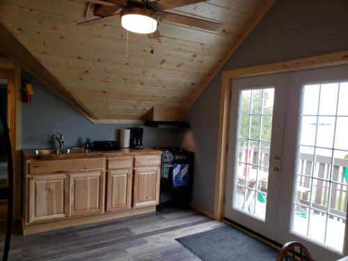 cocina con armarios de madera y techo en Steffen's Cedar Lodge 