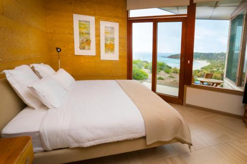 a bedroom with a bed with a view of the ocean at Sheoaks in Stokes Bay