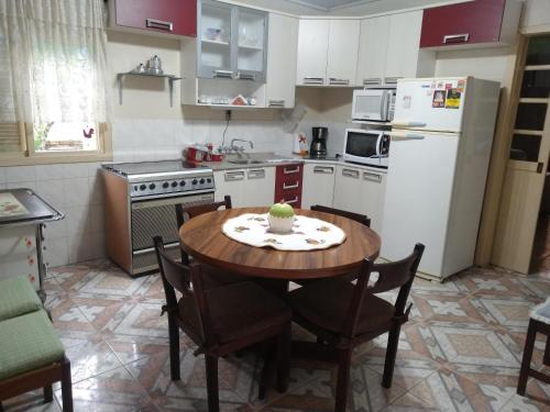 una pequeña cocina con mesa y nevera en Casa aconchegante em Canela, en Canela