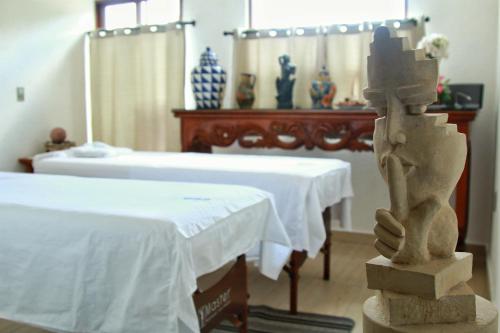 a room with two beds and a statue of a hand at Hotel Concierge Flor y Canto in Tepoztlán