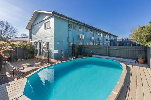 a swimming pool in front of a house at Taylors Motel in Ashburton