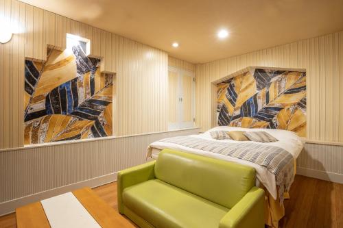 豊山にあるロコガーデン小牧のベッドルーム(ベッド1台、緑のソファ付)
