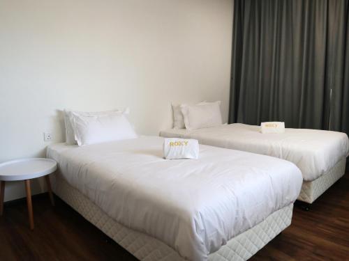 Una cama o camas en una habitación de Roxy Sematan Villa & Townhouse