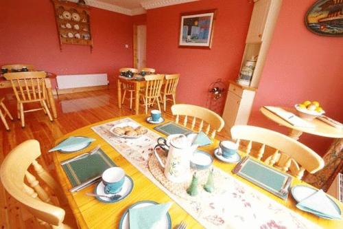 Sneem River Lodge Bed & Breakfast في سنيم: غرفة طعام مع طاولة وكراسي وغرفة طعام