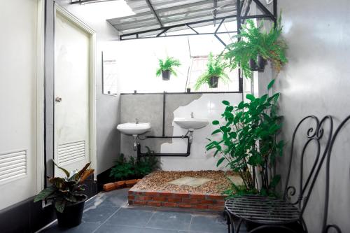 uma casa de banho com dois lavatórios e vasos de plantas em KAYAN Hostel em Chiang Mai