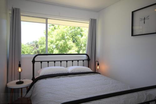a bedroom with a bed and a large window at Carawatha in Blackheath